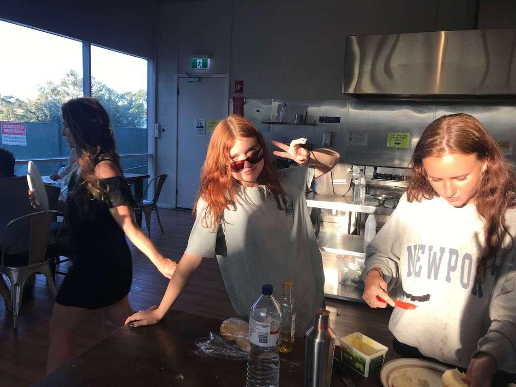 Two backpackers smiling while working outdoors in a vineyard